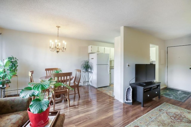 living area featuring a chandelier, a textured ceiling, a baseboard radiator, and light wood-style flooring