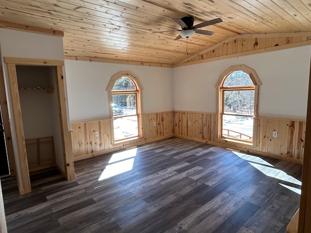 unfurnished room featuring lofted ceiling, dark wood-type flooring, wood ceiling, and wainscoting