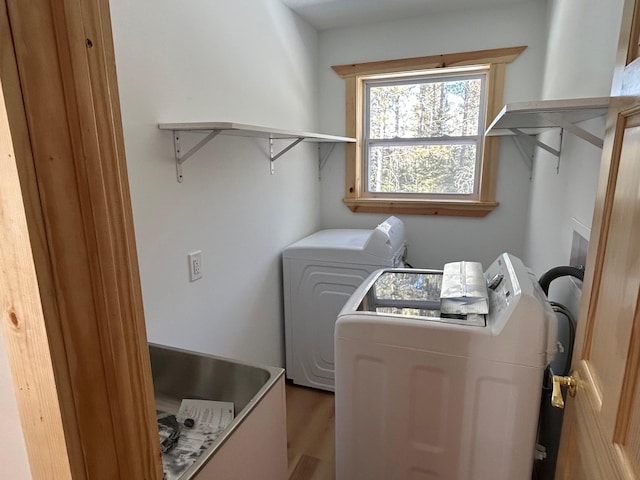 laundry area with independent washer and dryer, wood finished floors, and laundry area