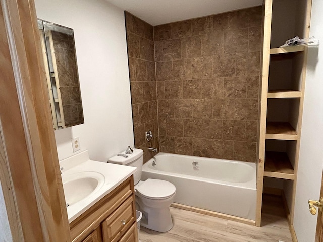 full bath with toilet, wood finished floors, vanity, and shower / tub combination