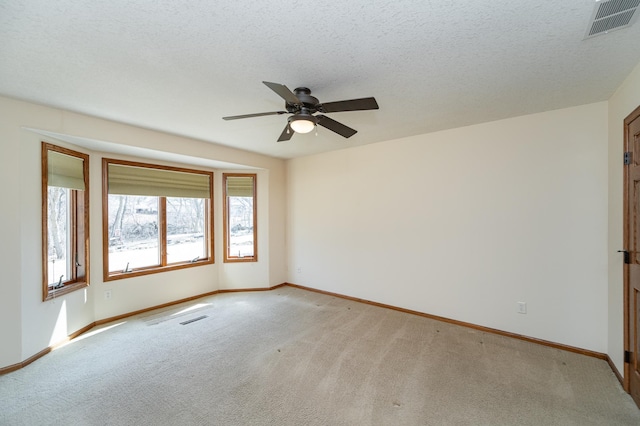 unfurnished room featuring light carpet, visible vents, a textured ceiling, and baseboards