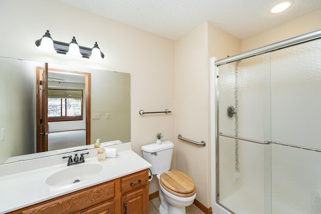 bathroom with baseboards, toilet, a stall shower, and vanity