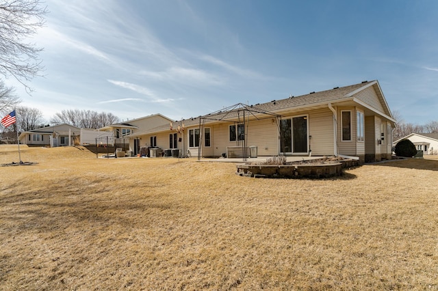 rear view of house featuring cooling unit, a lawn, and a patio area