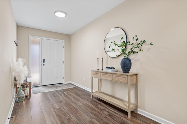 foyer featuring dark wood-style floors and baseboards