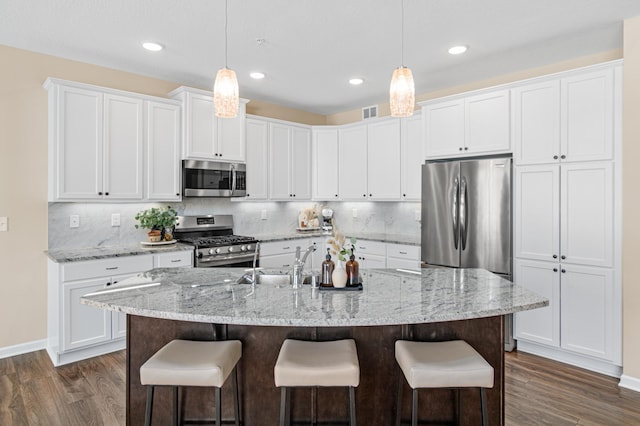 kitchen featuring dark wood-style floors, a breakfast bar area, and stainless steel appliances