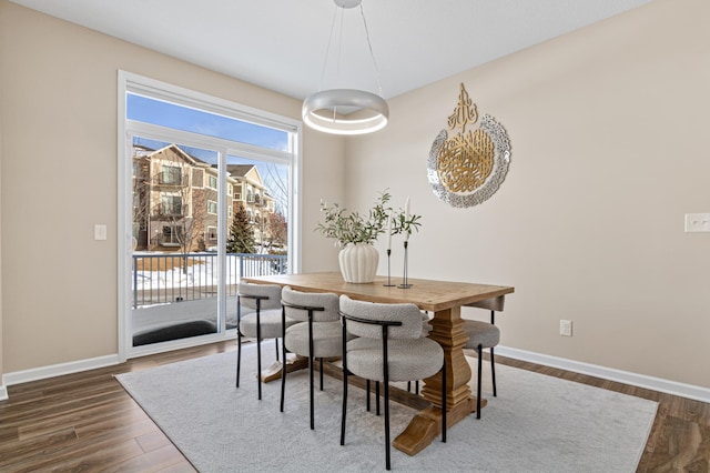 dining area featuring dark wood-style flooring and baseboards