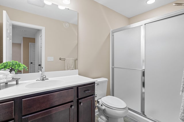 bathroom with a stall shower, vanity, and toilet