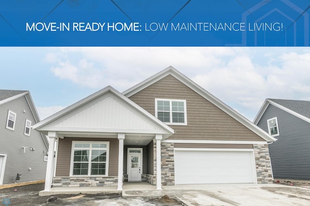 view of front of home featuring a garage, stone siding, a porch, and driveway