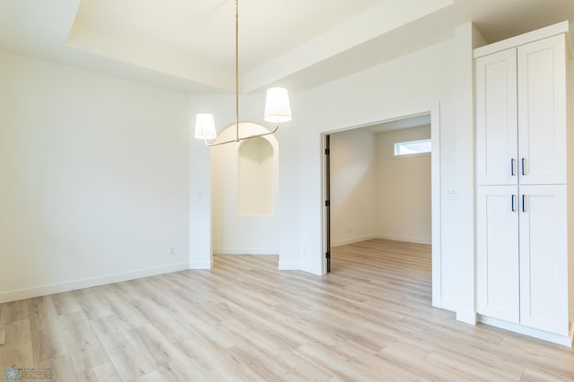 unfurnished dining area featuring baseboards and light wood-type flooring