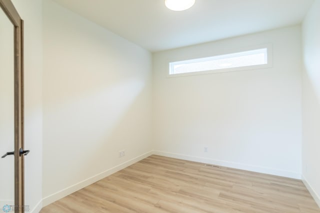 unfurnished room with light wood-type flooring and baseboards