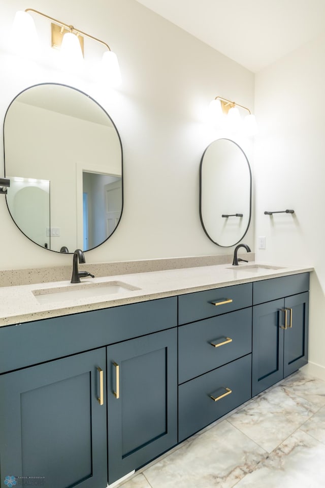 bathroom featuring double vanity, marble finish floor, and a sink