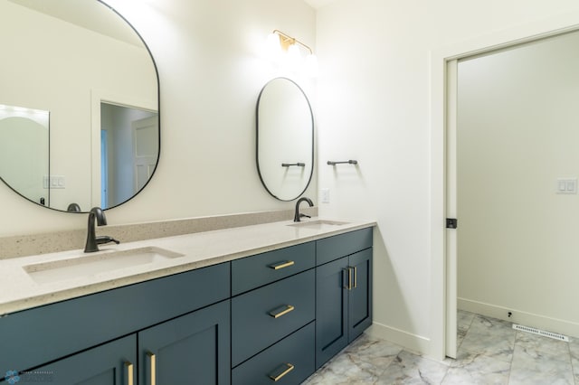 full bathroom featuring a sink, baseboards, marble finish floor, and double vanity