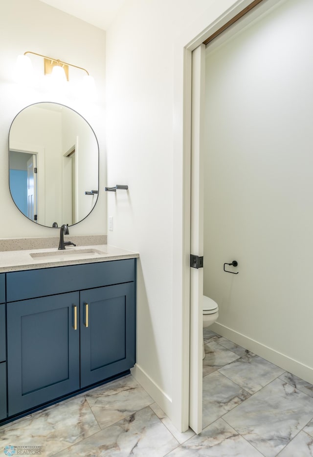 half bath with vanity, baseboards, and marble finish floor