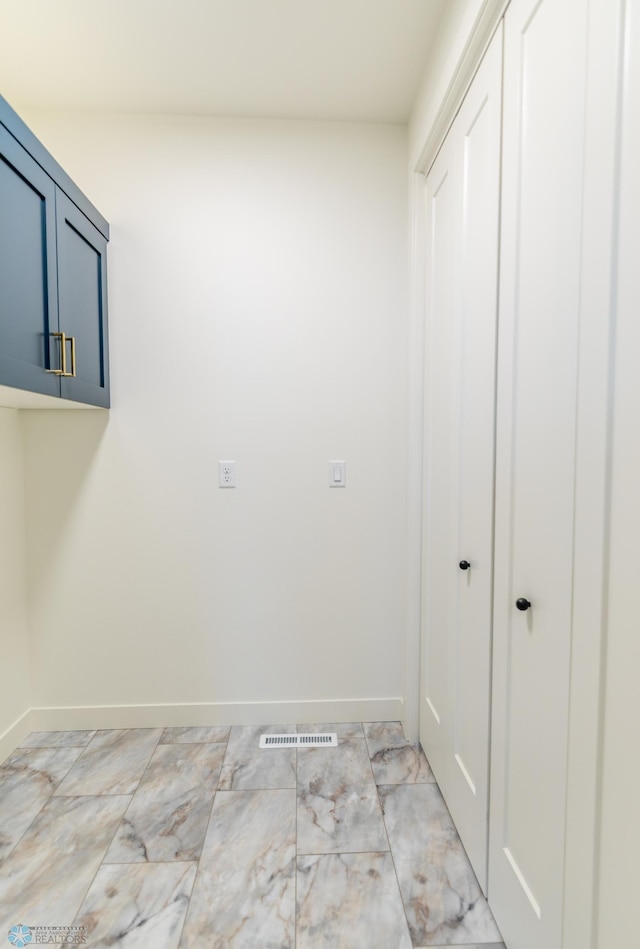 laundry room with visible vents, baseboards, and marble finish floor