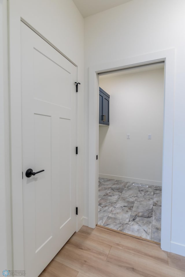 hall with light wood finished floors and baseboards