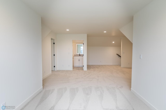 empty room with light colored carpet, recessed lighting, and baseboards