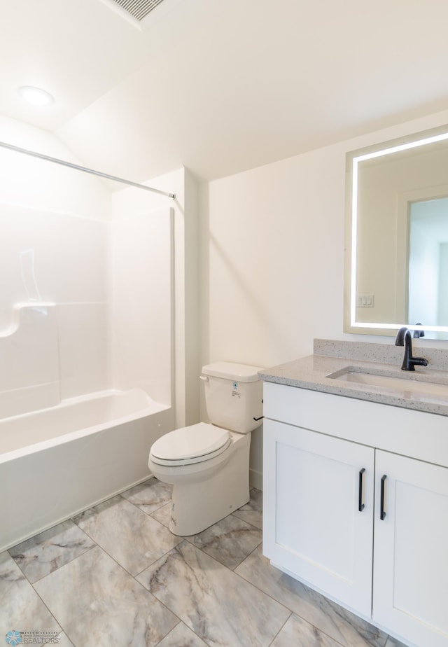 full bathroom with visible vents, toilet, bathing tub / shower combination, marble finish floor, and vanity