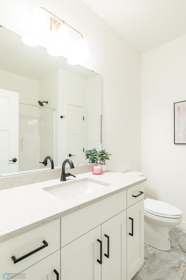 bathroom featuring marble look tile flooring, vanity, toilet, and a shower