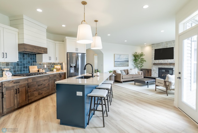 kitchen featuring appliances with stainless steel finishes, a sink, white cabinetry, a breakfast bar, and recessed lighting