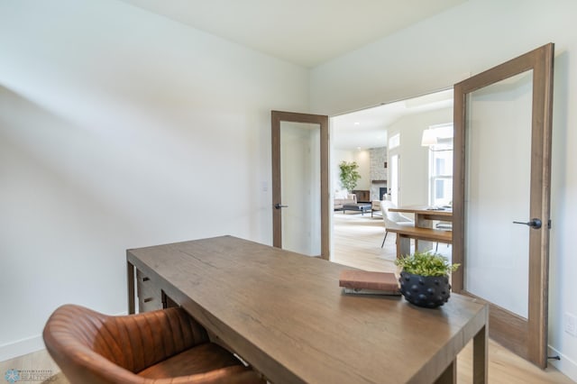 office space featuring light wood-type flooring and baseboards