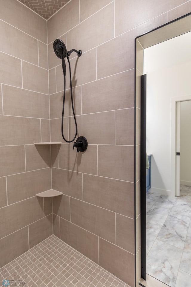 full bathroom featuring tiled shower and marble look tile flooring