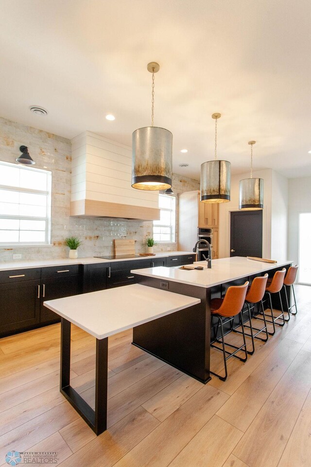 5172 Mira Way W, West Fargo, ND 58078 - kitchen with a breakfast bar, oven, a sink, backsplash, and light countertops