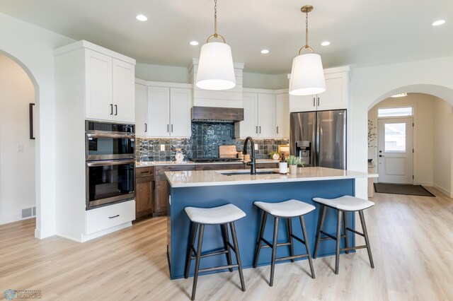 5172 Mira Way W, West Fargo, ND 58078 - kitchen with stainless steel appliances, arched walkways, a sink, tasteful backsplash, and light wood-style floors