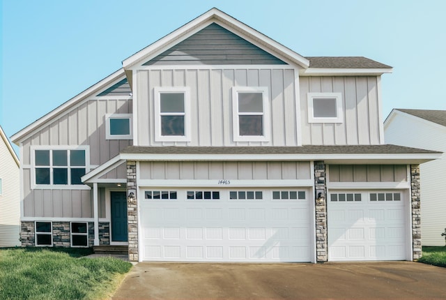 modern farmhouse with a garage, a shingled roof, concrete driveway, stone siding, and board and batten siding