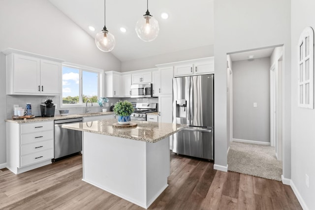 kitchen with dark wood finished floors, appliances with stainless steel finishes, white cabinets, and a sink