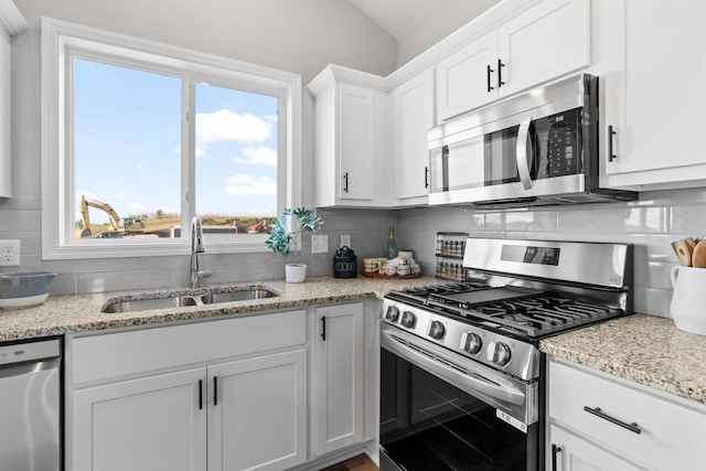 kitchen with backsplash, stainless steel appliances, and a sink