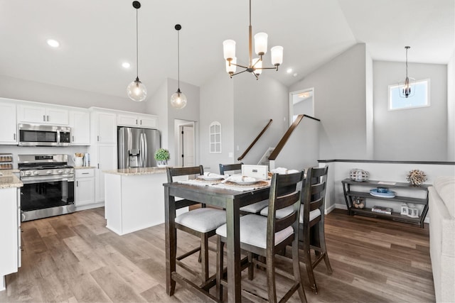 dining area with light wood finished floors, stairway, high vaulted ceiling, a chandelier, and recessed lighting