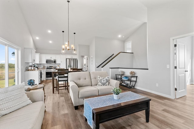 living area featuring light wood-style floors, recessed lighting, high vaulted ceiling, and baseboards