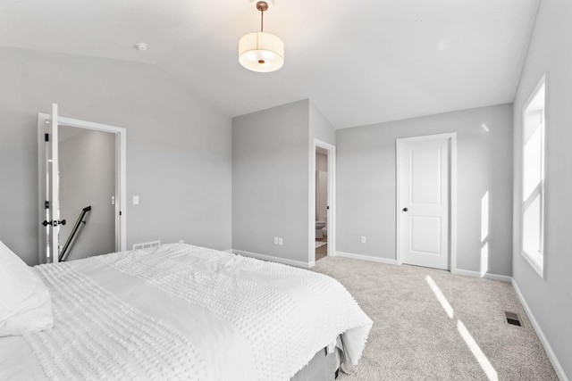 bedroom with lofted ceiling, baseboards, visible vents, and light colored carpet