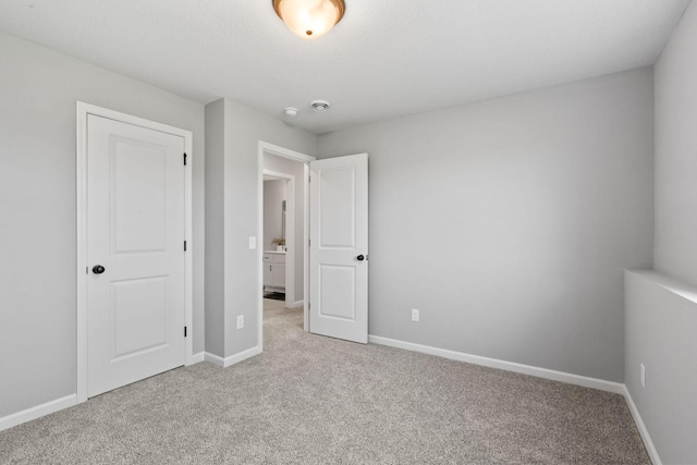 unfurnished bedroom with light carpet and baseboards