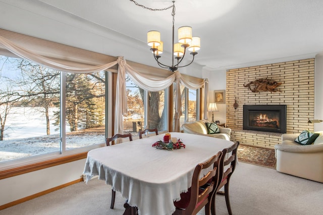 dining room featuring baseboards, carpet floors, a notable chandelier, and a fireplace