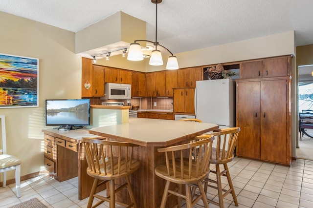 kitchen featuring white appliances, light tile patterned floors, light countertops, and brown cabinets