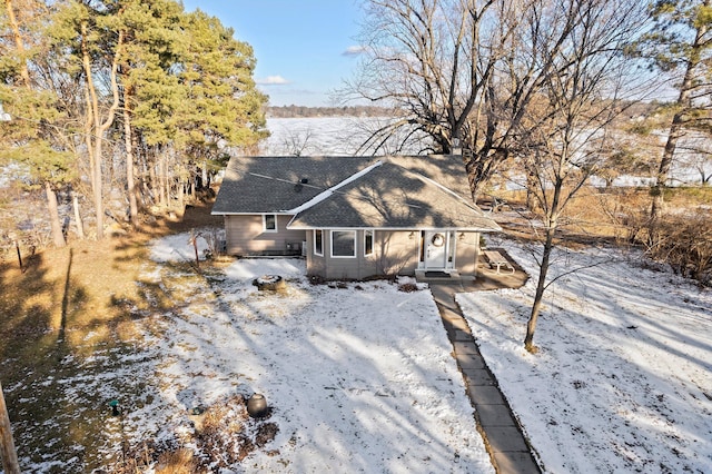 snow covered house with roof with shingles