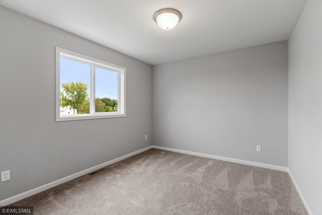 carpeted empty room with visible vents and baseboards