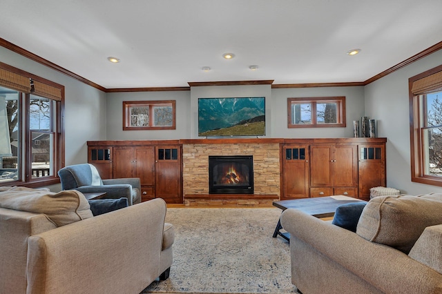 living room featuring ornamental molding, recessed lighting, and a stone fireplace