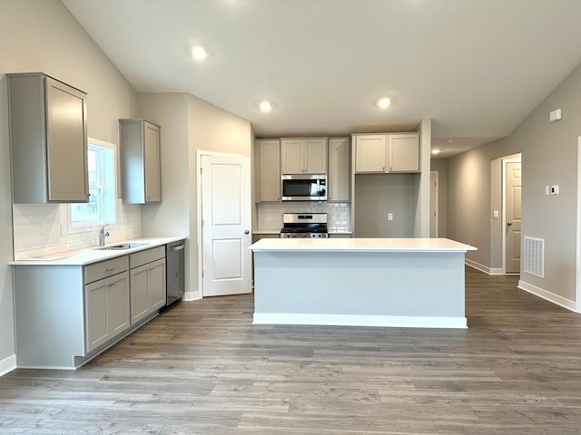 kitchen featuring visible vents, appliances with stainless steel finishes, gray cabinets, and a sink