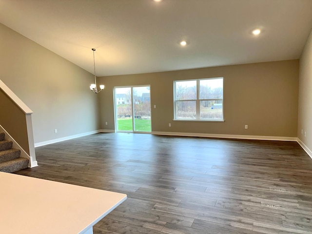 unfurnished living room featuring dark wood-style floors, stairs, baseboards, and an inviting chandelier