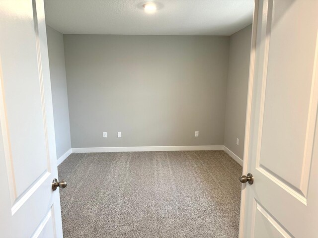 empty room with carpet and baseboards