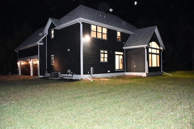 12424 126th Ave NE, Thief River Falls, MN 56701 - back of house at twilight featuring a yard, a garage, and a shingled roof