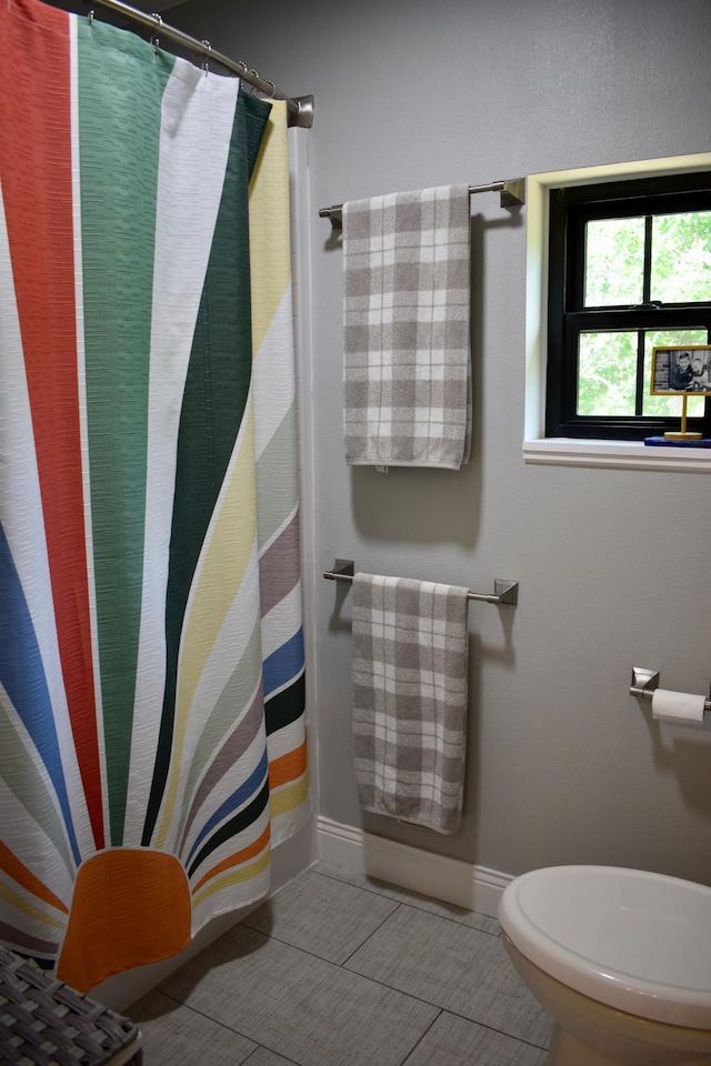 12424 126th Ave NE, Thief River Falls, MN 56701 - full bath with toilet, baseboards, curtained shower, and tile patterned floors