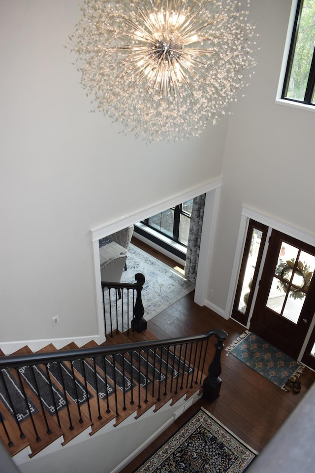 12424 126th Ave NE, Thief River Falls, MN 56701 - entryway with hardwood / wood-style floors, a chandelier, stairway, baseboards, and a towering ceiling
