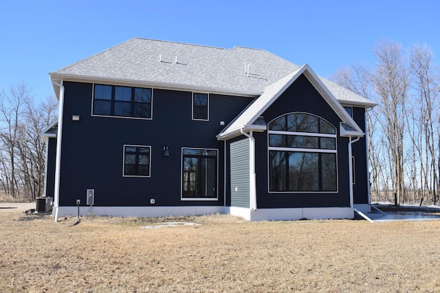 12424 126th Ave NE, Thief River Falls, MN 56701 - rear view of house featuring central air condition unit, a shingled roof, and a yard