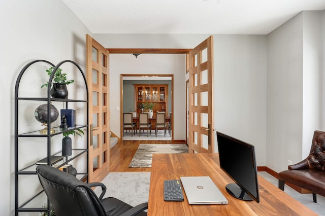 office space featuring french doors, wood finished floors, and baseboards