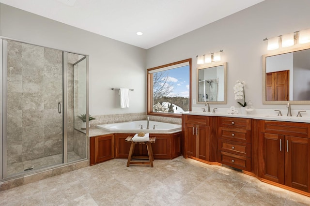 bathroom featuring a bath, a stall shower, double vanity, and a sink