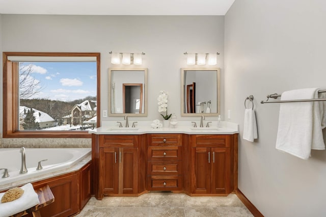 bathroom with a garden tub, a sink, and double vanity