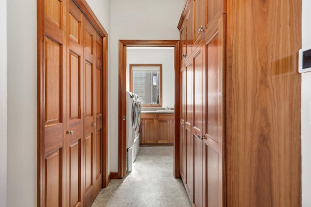 hallway featuring washing machine and dryer and a sink